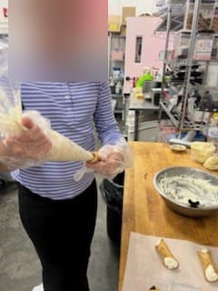Piping cannoli filling at Antonio's Macarons camp